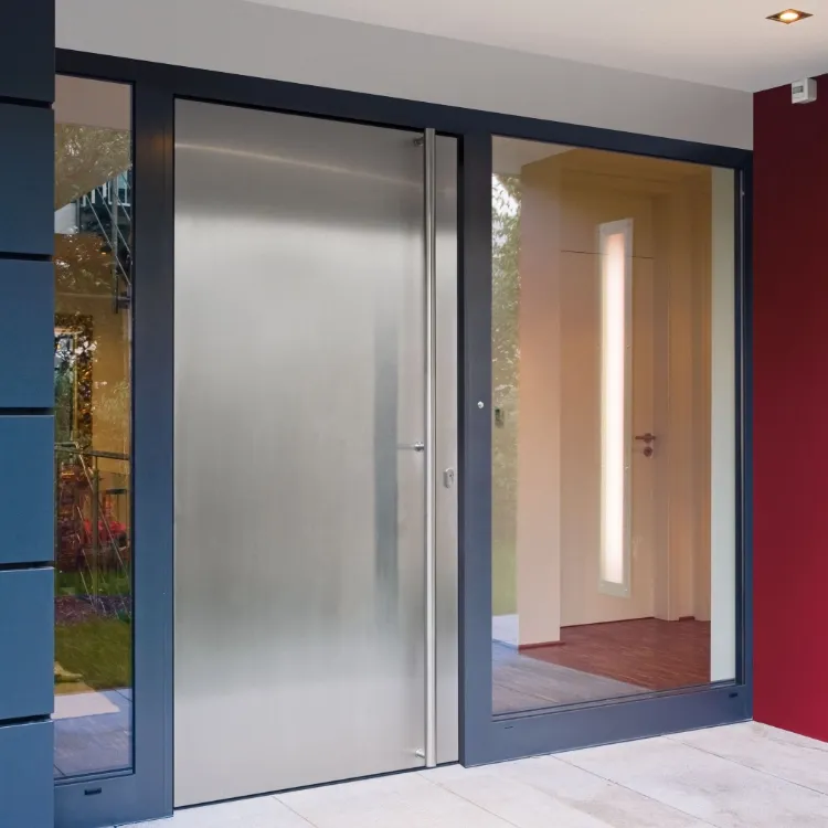 Puerta de entrada moderna con acabado metálico y cristaleras laterales en vivienda contemporánea