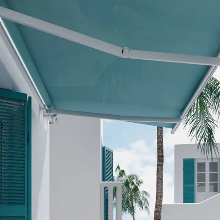 Toldo extensible azul instalado en terraza de vivienda blanca con contraventanas turquesa