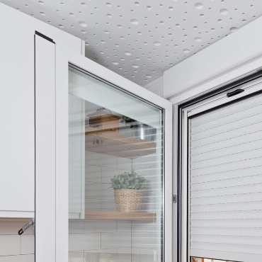 Detalle de cajón de persiana integrado en ventana de cocina moderna con carpintería blanca