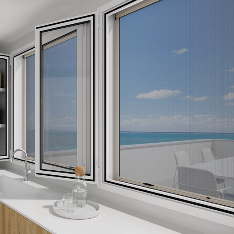 Mosquitera enrollable instalada en ventana abatible con vistas al mar, en cocina luminosa