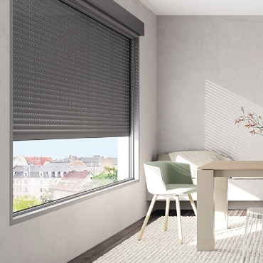 Instalación de persiana enrollable de aluminio extrusionado gris en salón moderno con vistas