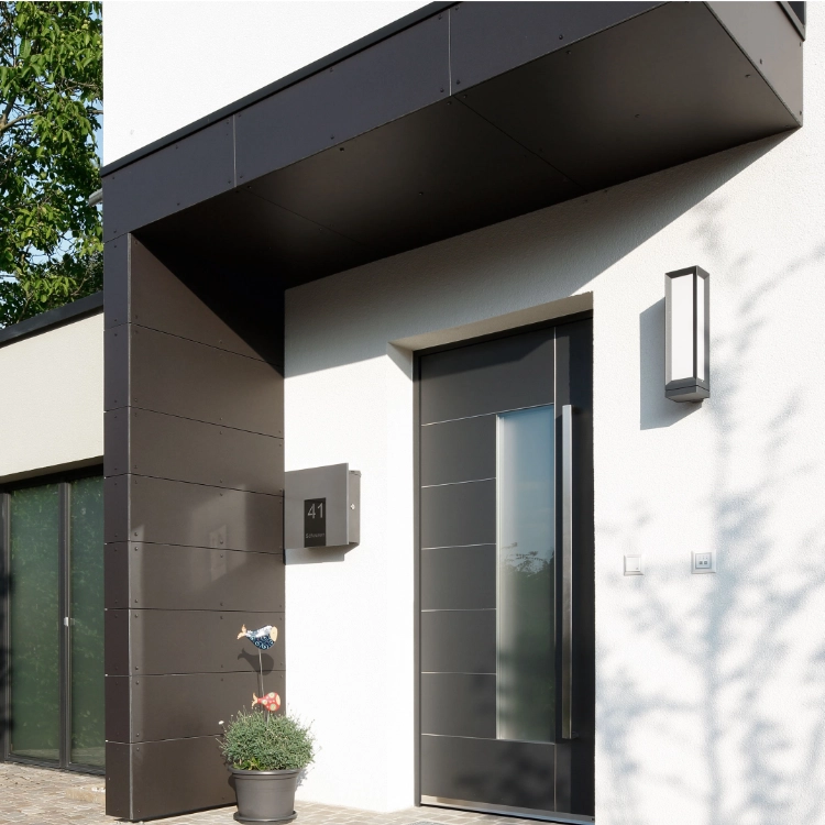 Puerta de entrada con panel decorativo negro, líneas horizontales y tirador embutido